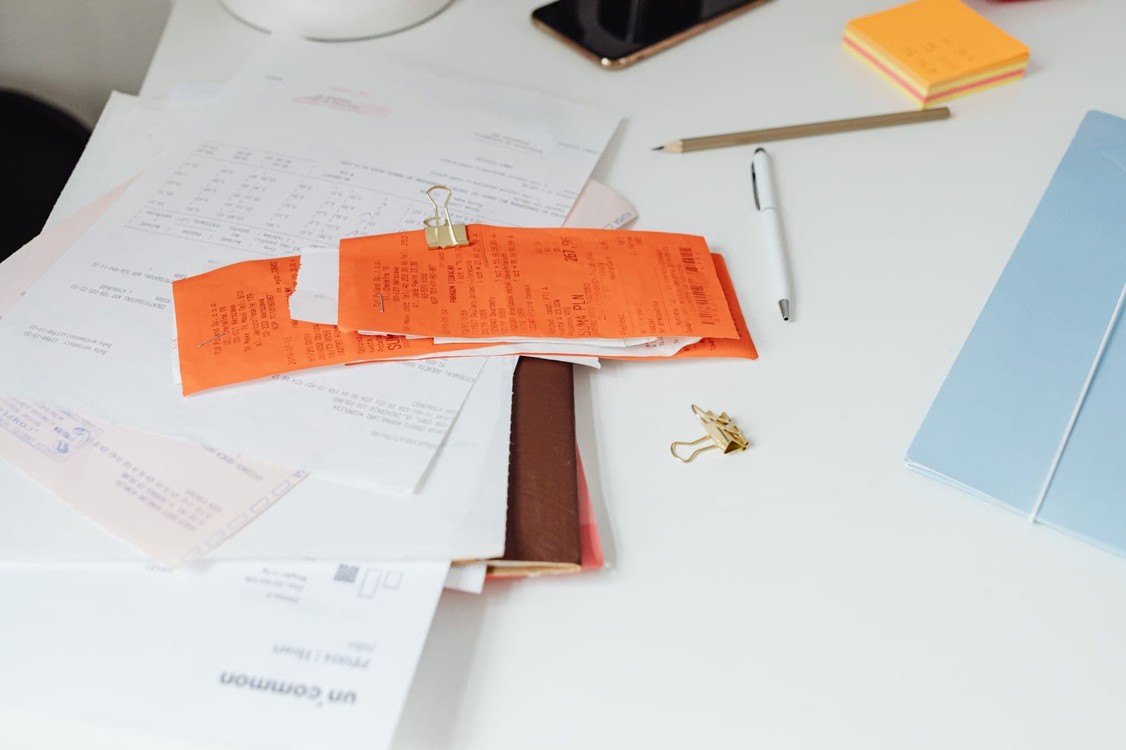 A printed receipt and a pen on a desk surface