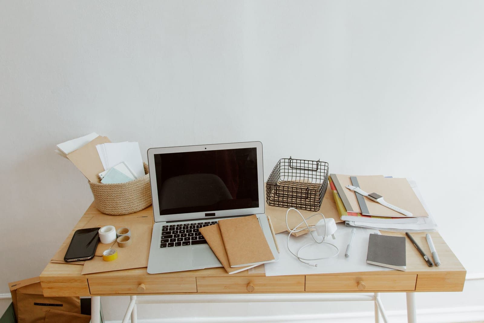 A decluttered desk with a notebook and a few organized items