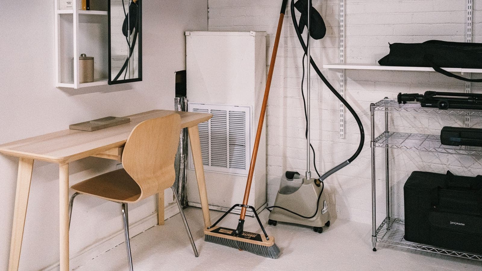 A compact home office corner with shelving and storage boxes